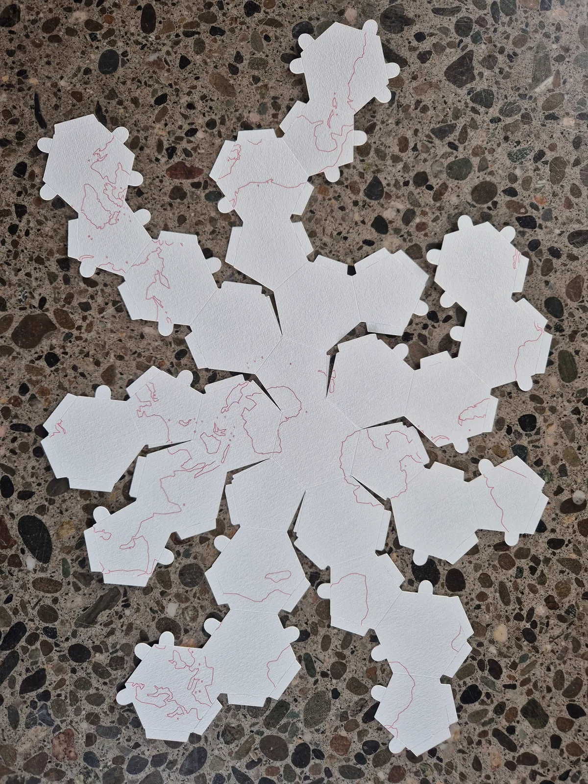 White-card globe patterns laid flat, showing different face shapes, fold lines and tabs.